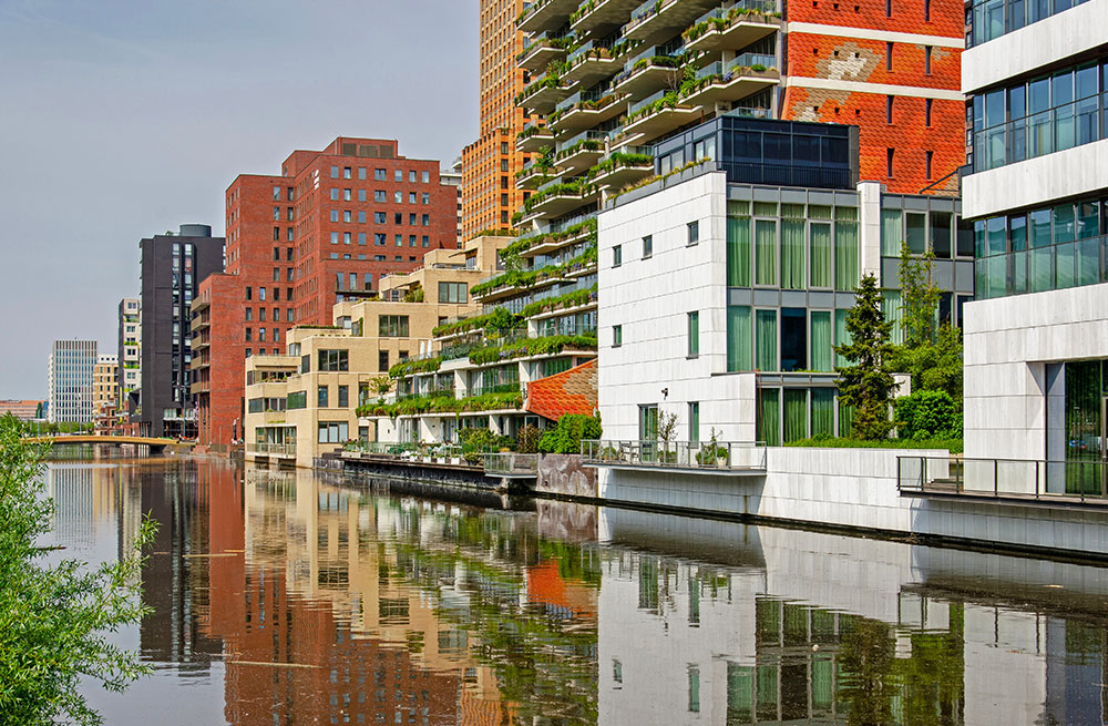 Amsterdam-colorful-row-of-modern-buildings-reflecting-in-a-canal-in-the-Zuidas-district